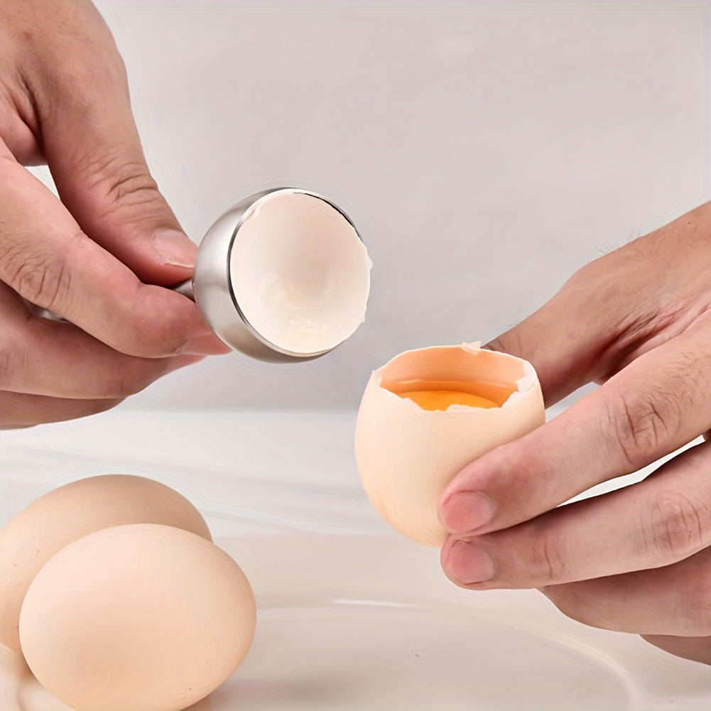 Händer som öppnar ägg med Kitchlark äggknäckare, äggula synlig i skalet